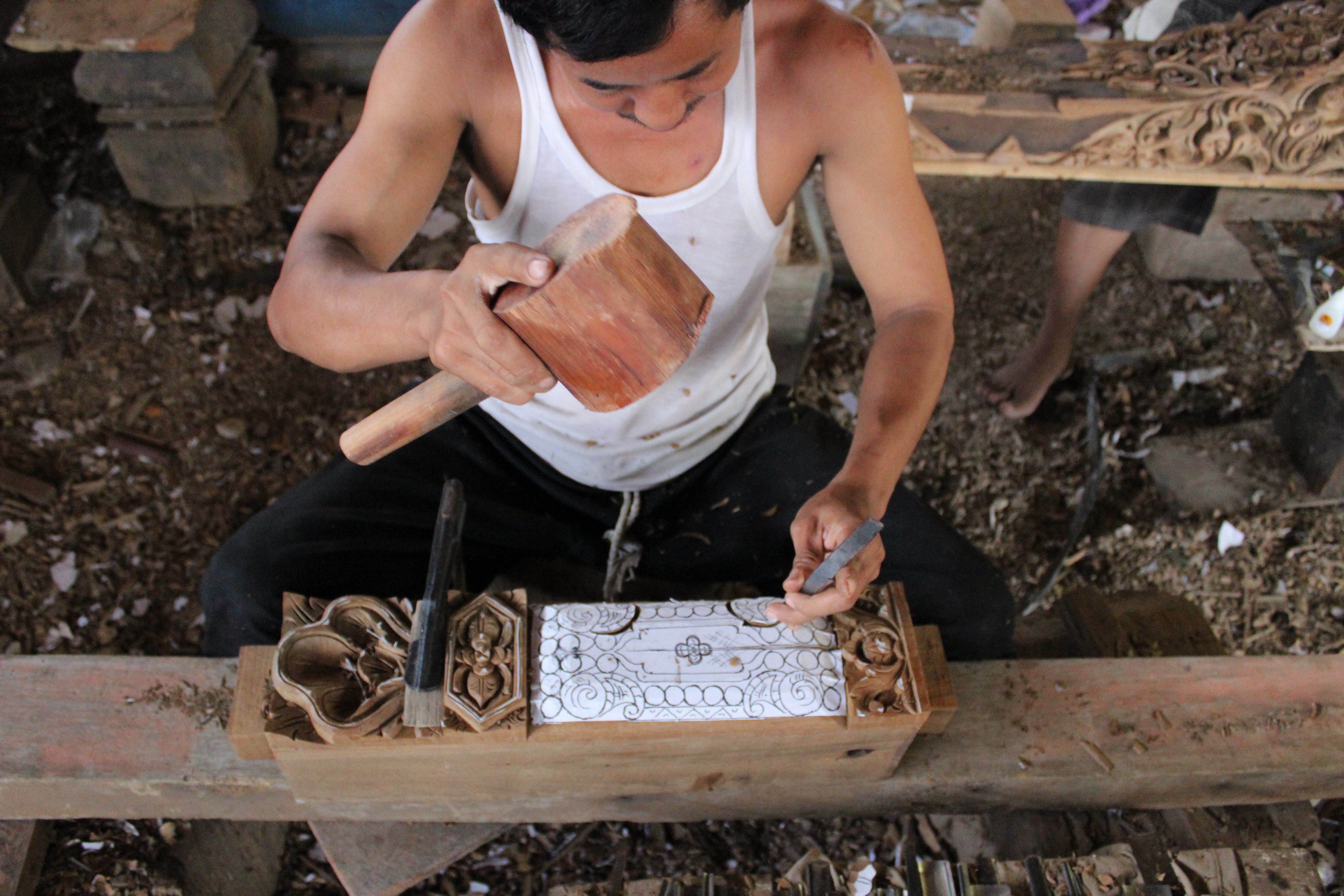 Jepara artisan carving a custom timber detail