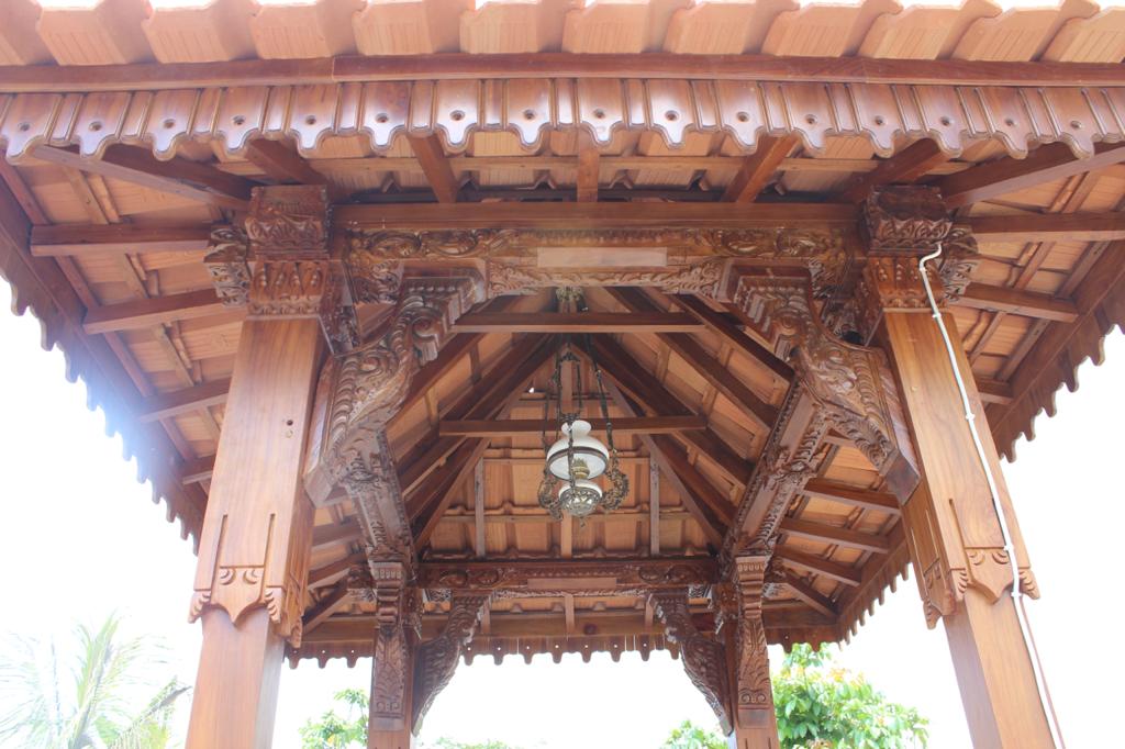 Carved timber structure beneath a pendopo roof